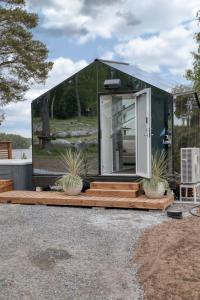 a glass house with a deck and potted plants at Lunar Igloos - Kaamos - Ellivuori Resort in Karkku +2 photos