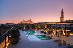 a rooftop patio with a pool on a building at Sant Francesc Hotel Singular in Palma de Mallorca