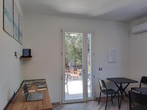 a living room with a table and a door to a patio at I Sette Ulivi Bed and Breakfast in Tergu