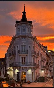 a large white building with a sunset in the background at Apartamento Casa la Rubia Jaca in Jaca