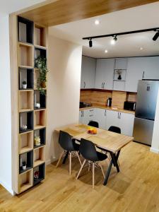 a kitchen with a wooden table and chairs at MiKi Apartmán Durrës in Durrës