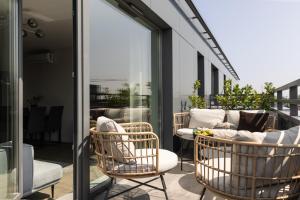 a balcony with wicker chairs and a couch at Scala Apartamenty by Moderna Profit- Łąkowa 60G z parkingiem in Gdańsk