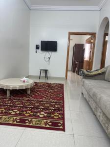 a living room with a couch and a coffee table at ديار الكرم للشقق المفروشه in Baljurashi
