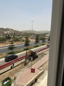 a construction site with a truck and a car on a road at ديار الكرم للشقق المفروشه in Baljurashi