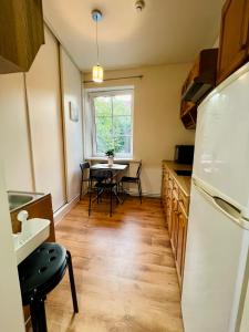 a kitchen with a table and a white refrigerator at Manto Apartment in Klaipėda +23 photos