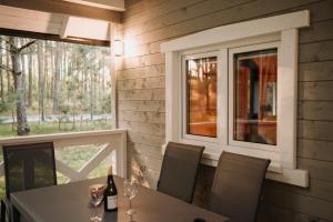 a dining room with a table and a window at Zakątek Wygonin Jacuzzi & Sauna w Lesie - KASZUBY in Wygonin