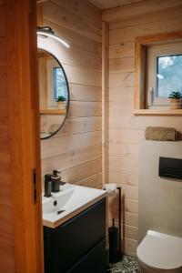a bathroom with a sink and a mirror at Zakątek Wygonin Jacuzzi & Sauna w Lesie - KASZUBY in Wygonin +13 photos