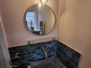 un baño con espejo y lavabo en Fishermans Locker, en Bridport