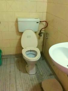 a bathroom with a toilet and a sink at Hotel Queen in Darjeeling