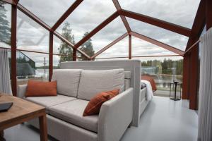 a living room with a couch in a room with windows at Lunar Igloos - Ruska - Ellivuori Resort in Karkku