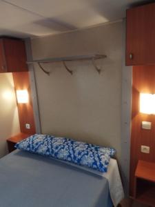 a small bedroom with a bed and two lights at Móvilhome in Chiclana de la Frontera