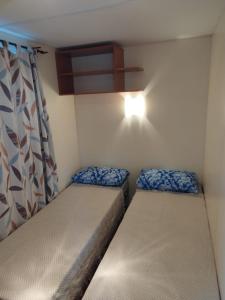 a small room with two beds and a light at Móvilhome in Chiclana de la Frontera