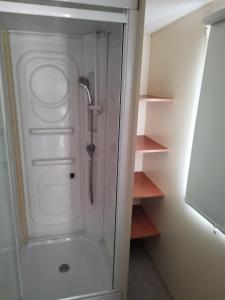 a shower with a glass door in a bathroom at Móvilhome in Chiclana de la Frontera