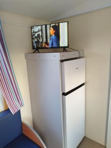 a flat screen tv on top of a refrigerator at Móvilhome in Chiclana de la Frontera +6 photos