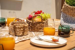 a table with a plate of food and baskets of fruit at Kallisti Palace - Private Pool with Hydromassage in Kissamos