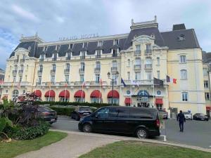 une camionnette garée devant un grand bâtiment dans l'établissement Duplex mer F2 TV Fibre 5 vélos à disposition, à Cabourg