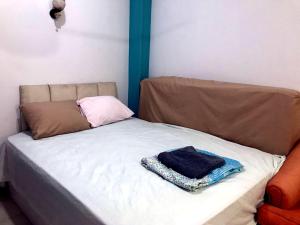 a bed with a brown headboard and a towel on it at room 3 a room in Hostel of 4 rooms in Hurghada