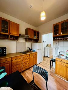 a kitchen with wooden cabinets and a table and chairs at Manto Apartment in Klaipėda