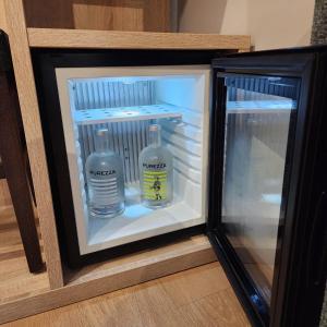 a mini refrigerator with two bottles of water in it at Hotel Saint Augustin in Strasbourg