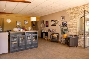 a waiting room with a counter and a stone wall at Logis Hôtel Le Manoir & Lounge in Apt
