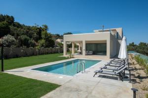 a villa with a swimming pool and lawn at Villa Neratzia-Luxury Escape in Nerianá