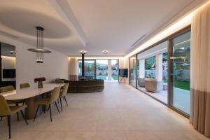 a dining room and living room with a table and chairs at Villa Neratzia-Luxury Escape in Nerianá