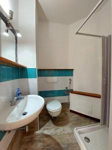 a bathroom with a white sink and a toilet at Casa del Sole Guest House in Alghero