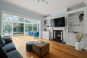 un soggiorno con divano e camino di Spacious 3-Bedroom Family Home in Kingston with Garden, Smart TVs & Fast WiFi - Ideal for Longer Stays a Kingston upon Thames