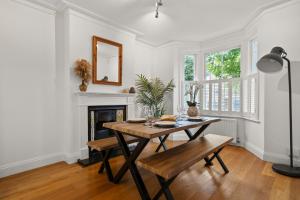 una sala da pranzo con tavolo e camino di Spacious 3-Bedroom Family Home in Kingston with Garden, Smart TVs & Fast WiFi - Ideal for Longer Stays a Kingston upon Thames