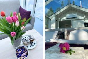 a table with a vase of flowers and a bowl of donuts at Lunar Igloos - Lumi - Ellivuori Resort in Karkku