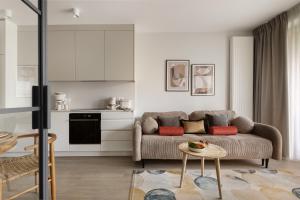 a living room with a couch and a table at Scala Apartamenty by Moderna Profit - Łąkowa 60H z parkingiem in Gdańsk
