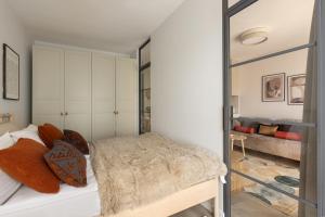 a bedroom with a bed and a sliding glass door at Scala Apartamenty by Moderna Profit - Łąkowa 60H z parkingiem in Gdańsk