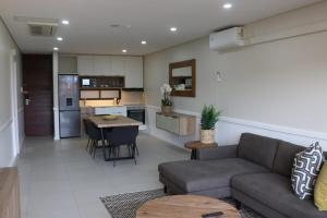 バリートにあるZimbali Ocean Suiteのソファとテーブルのあるリビングルームとキッチン
