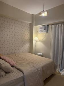 a bedroom with a bed with a fan and a lamp at Welcome to Casa Sheridan Your cozy escape in the heart of the metro Whet in Manila