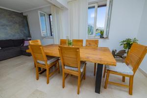 a dining room with a wooden table and chairs at Posejdon Apartments in Korčula