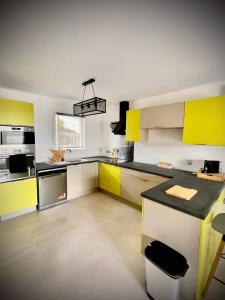 a kitchen with yellow and white cabinets and a counter at KALME Spa&Sauna - Maison avec Spa et Sauna privatifs in Chécy