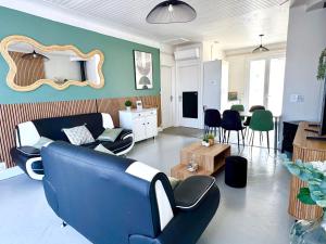 a living room with a blue couch and a table at Caporizon - Villa Jan Lou - 3 chambres - Grande terrasse in Labenne