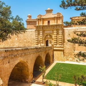 un vecchio edificio in pietra con un ponte e l'erba di Maleth Inn a Rabat