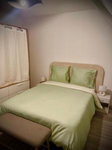a bedroom with a large bed with green pillows at KALME Spa&Sauna - Maison avec Spa et Sauna privatifs in Chécy