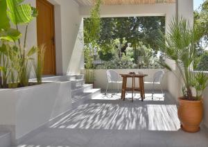 a patio with a table and chairs and plants at Swell Living Double Room in Asprovalta