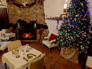 a living room with a christmas tree and a fireplace at Casa KiSi Cottage, Rural Boutique Bed & Breakfast in Málaga