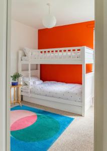 a room with two bunk beds and an orange wall at Secluded 3 bed cottage in private parkland in Brockenhurst