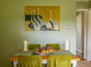 a dining room table with a basket of fruit and two candles at Secluded 3 bed cottage in private parkland in Brockenhurst