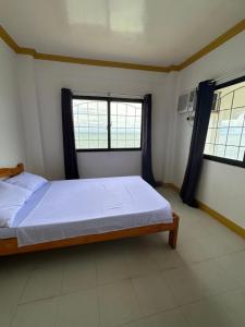 a bedroom with a bed and two windows at Becca's Vacation House 
