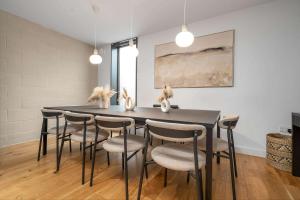 a dining room with a black table and chairs at West Townhouse by CasaCity in Manchester