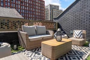 a patio with wicker chairs and a coffee table at West Townhouse by CasaCity in Manchester