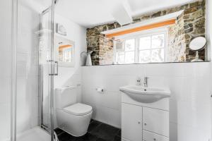 a white bathroom with a toilet and a sink at Cleave Cottage in Crackington Haven +41 photos