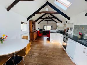 a kitchen with a white counter top and a table at Cleave Cottage in Crackington Haven