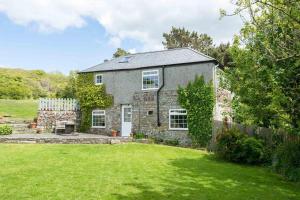 an old stone house with a grass yard at Cleave Cottage in Crackington Haven