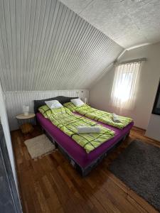een slaapkamer met een groot bed op zolder bij Berzsenyi Ház in Balatonfenyves